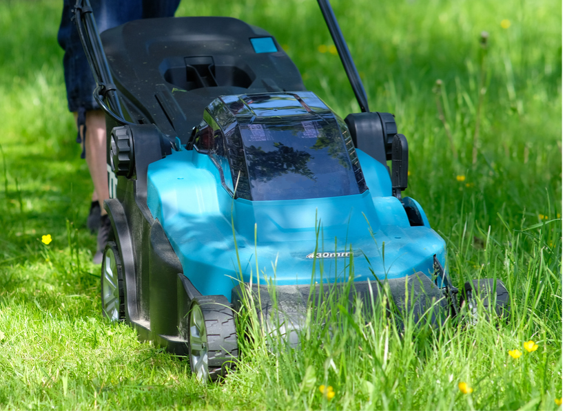 A person mowing a lawn with a lawnmower